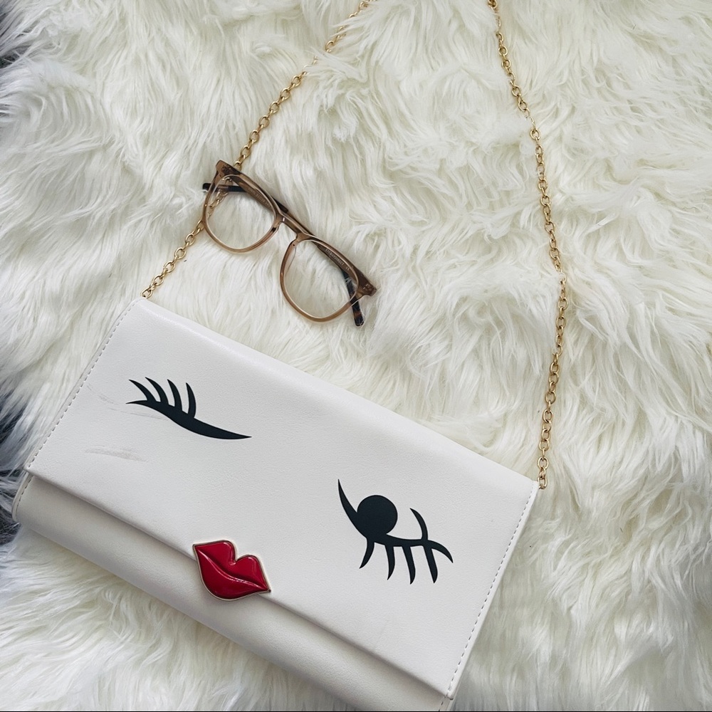 White clutch bag with gold chain. Slight stain on front.